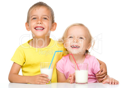 Cute little girl and boy are drinking milk