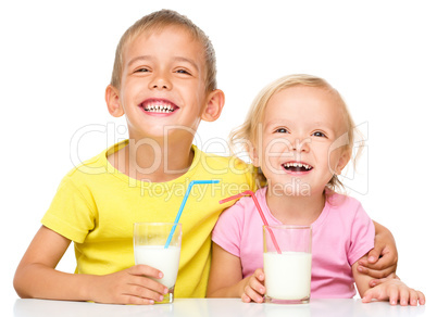 Cute little girl and boy are drinking milk