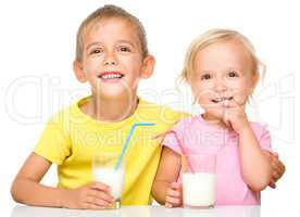 Cute little girl and boy are drinking milk