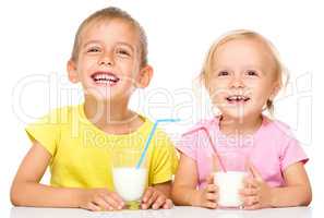 Cute little girl and boy are drinking milk