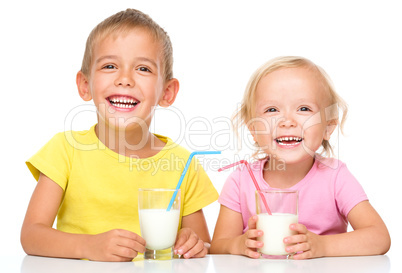 Cute little girl and boy are drinking milk