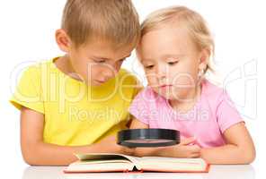 Little girl and boy are reading book
