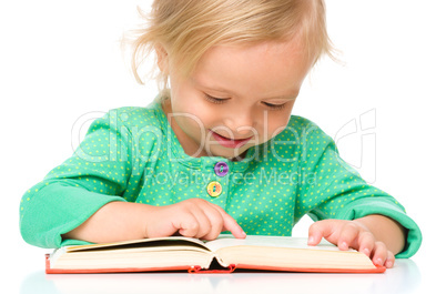 Little girl is reading her book