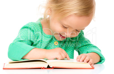 Little girl is reading her book