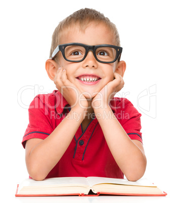 Little boy is reading a book