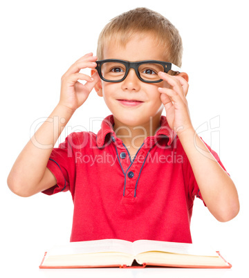 Little boy is reading a book