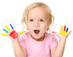 Portrait of a cute little girl playing with paints