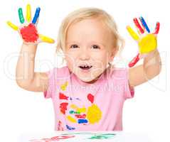 Portrait of a cute little girl playing with paints