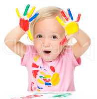 Portrait of a cute little girl playing with paints