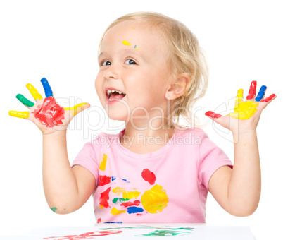 Portrait of a cute little girl playing with paints