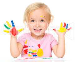 Portrait of a cute little girl playing with paints