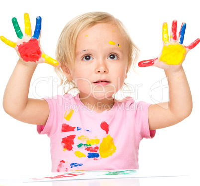 Portrait of a cute little girl playing with paints