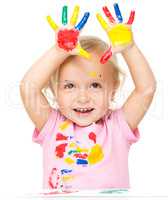 Portrait of a cute little girl playing with paints