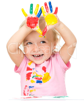 Portrait of a cute little girl playing with paints