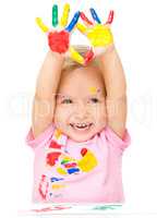 Portrait of a cute little girl playing with paints