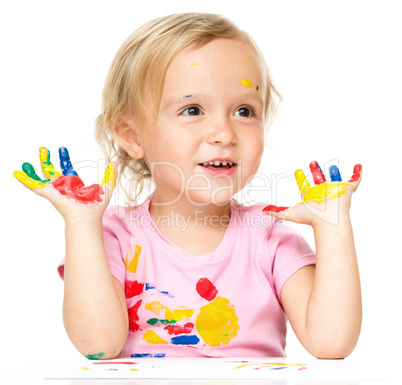 Portrait of a cute little girl playing with paints