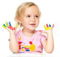 Portrait of a cute little girl playing with paints