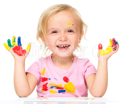 Portrait of a cute little girl playing with paints