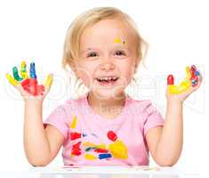 Portrait of a cute little girl playing with paints