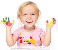 Portrait of a cute little girl playing with paints