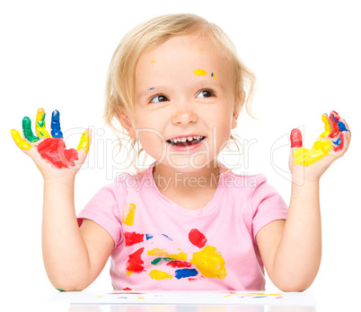 Portrait of a cute little girl playing with paints