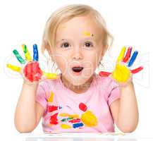 Portrait of a cute little girl playing with paints