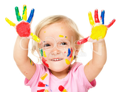 Portrait of a cute little girl playing with paints