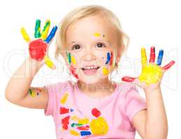 Portrait of a cute little girl playing with paints