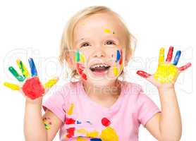 Portrait of a cute little girl playing with paints