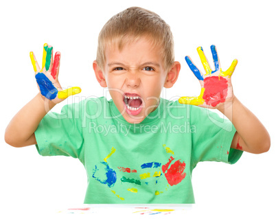 Portrait of a cute boy playing with paints