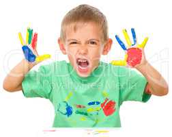 Portrait of a cute boy playing with paints