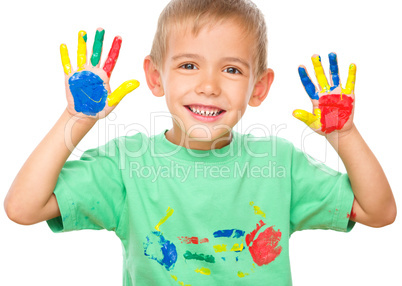 Portrait of a cute boy playing with paints