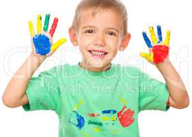 Portrait of a cute boy playing with paints