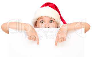 Little girl in santa hat is holding blank board