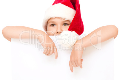 Little girl in santa hat is holding blank board