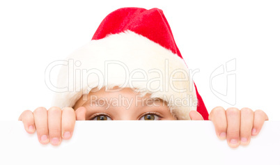 Little girl in santa hat is holding blank board