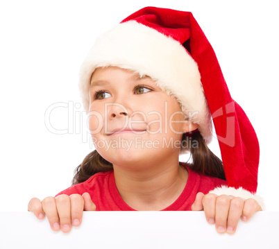 Little girl in santa hat is holding blank board