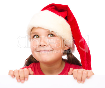 Little girl in santa hat is holding blank board