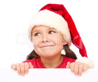 Little girl in santa hat is holding blank board