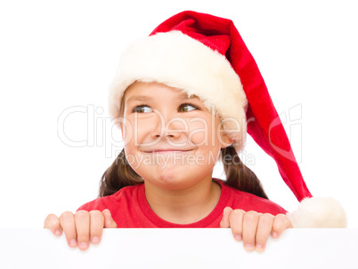 Little girl in santa hat is holding blank board