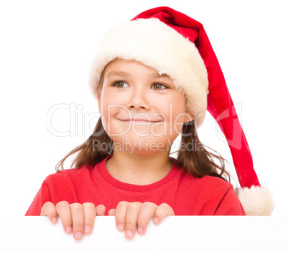 Little girl in santa hat is holding blank board