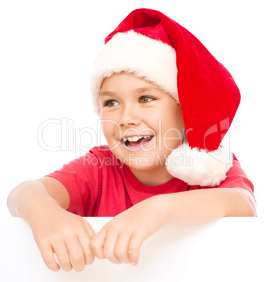 Little girl in santa hat is holding blank board