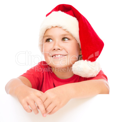 Little girl in santa hat is holding blank board