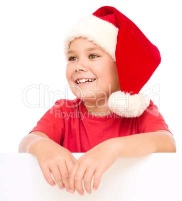 Little girl in santa hat is holding blank board