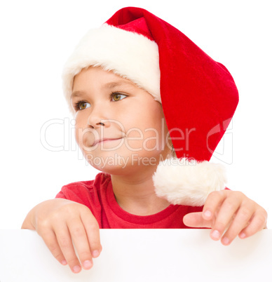 Little girl in santa hat is holding blank board