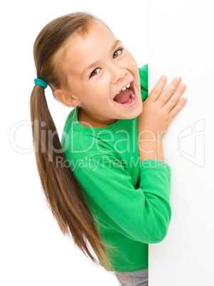 Little girl is looking from out blank board