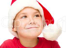 Little girl in santa hat is daydreaming