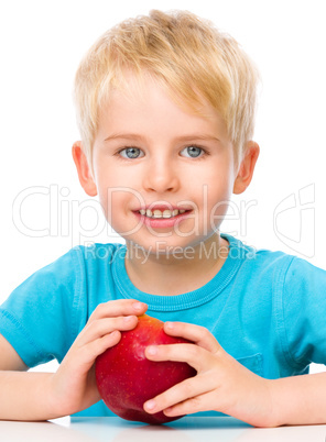 Portrait of a cute little boy with red apple