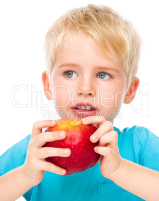 Portrait of a cute little boy with red apple