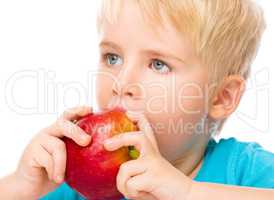 Portrait of a cute little boy with red apple